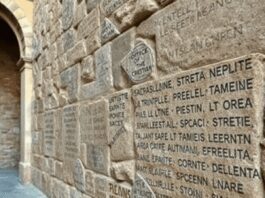Ancient Roman stone wall with authentic Latin graffiti inscriptions depicting public and private markings from the Roman Republic era in a historic...